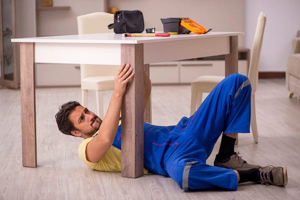 Un bricoleur en train de réparer une table Un bricoleur particulier en train de réparer une table