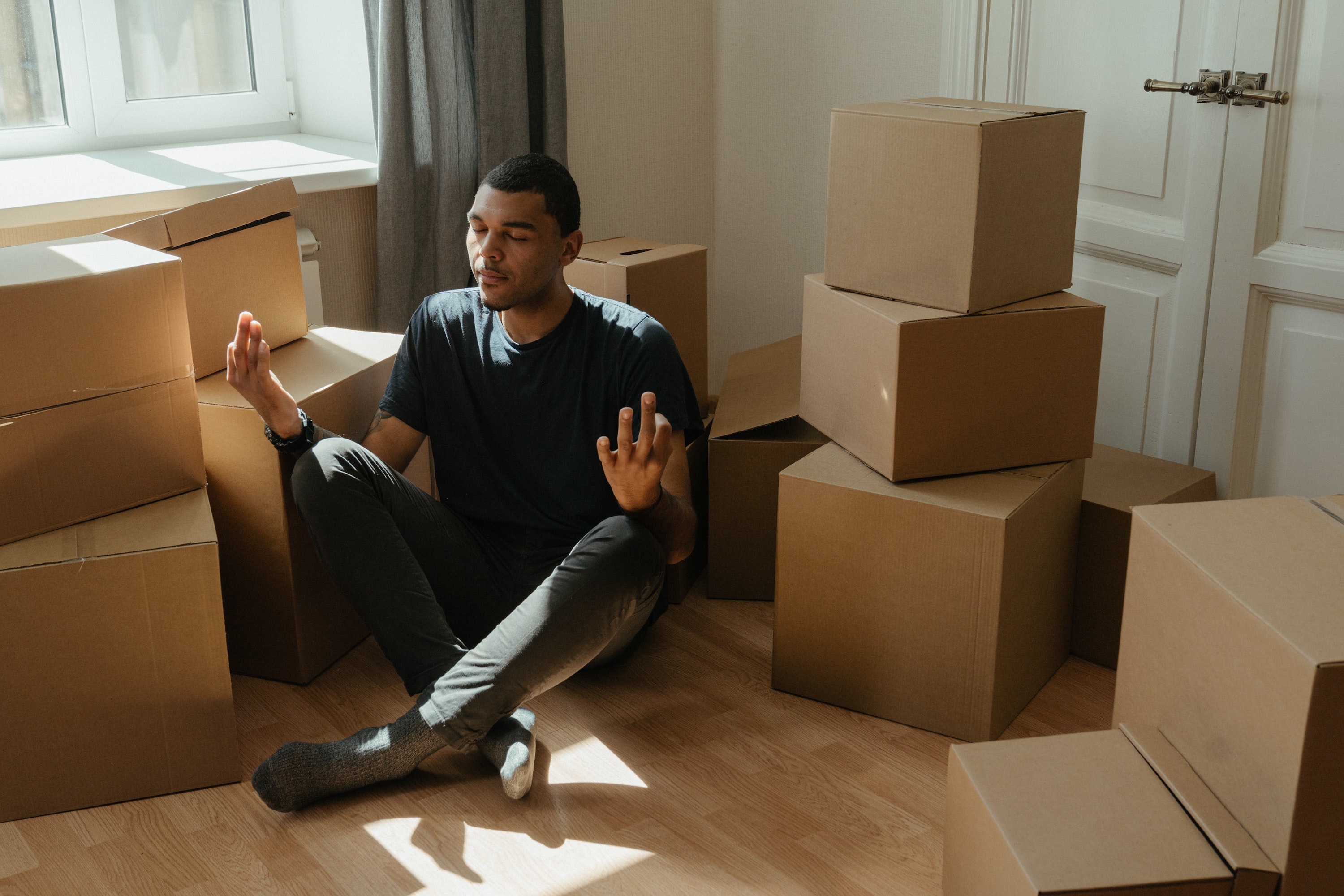 Un homme zen au milieu de cartons de déménagement