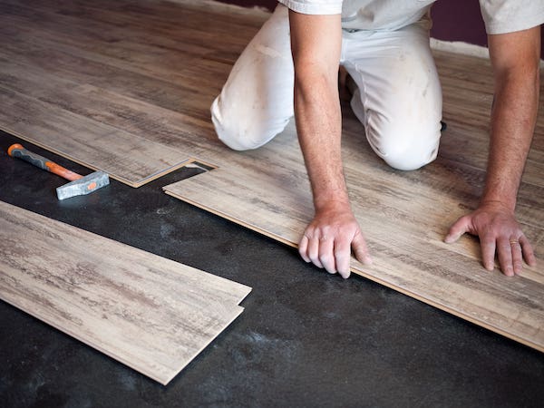 Un bricoleur en train de poser du parquet